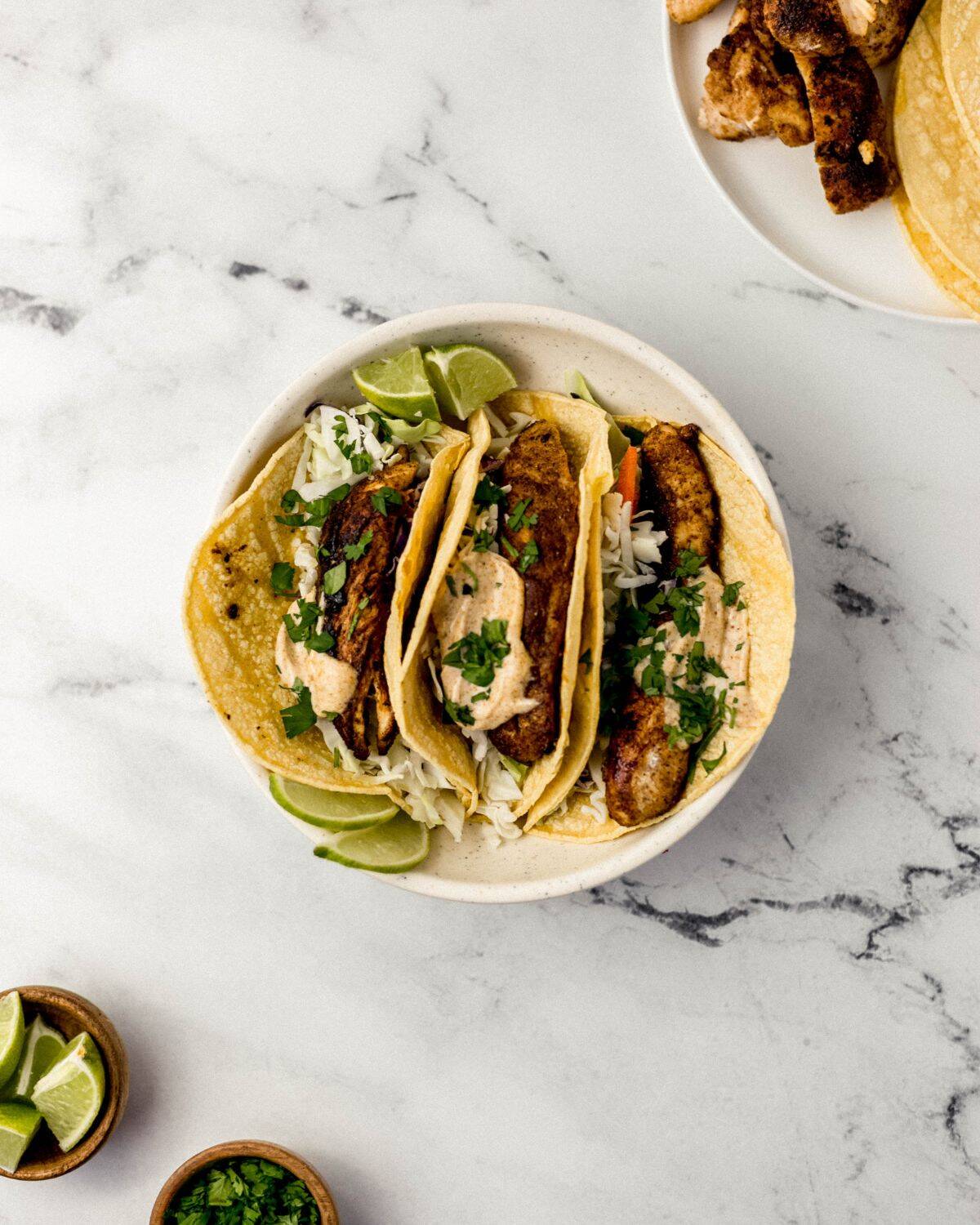 Jerk Chicken Tacos Simply LaKita 2 Overhead view of finished taco in white bowl on marble surface.