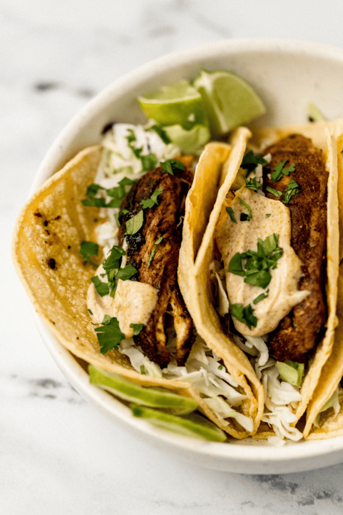 close up view of finished tacos in large white bowl