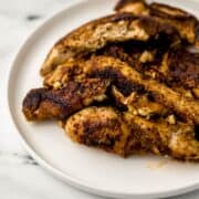 Close up front view of jerk chicken on white plate.