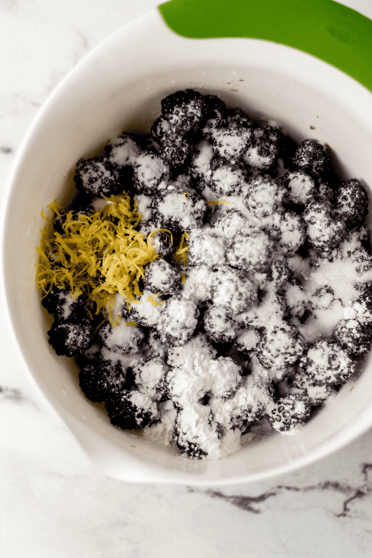 ingredients to make blackberry filling added to large white mixing bowl