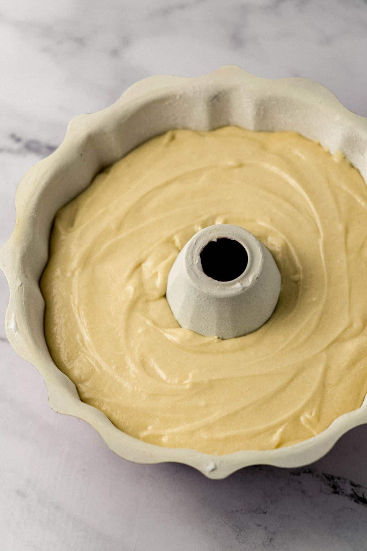 cake mixture added to prepared cake pan before baking 