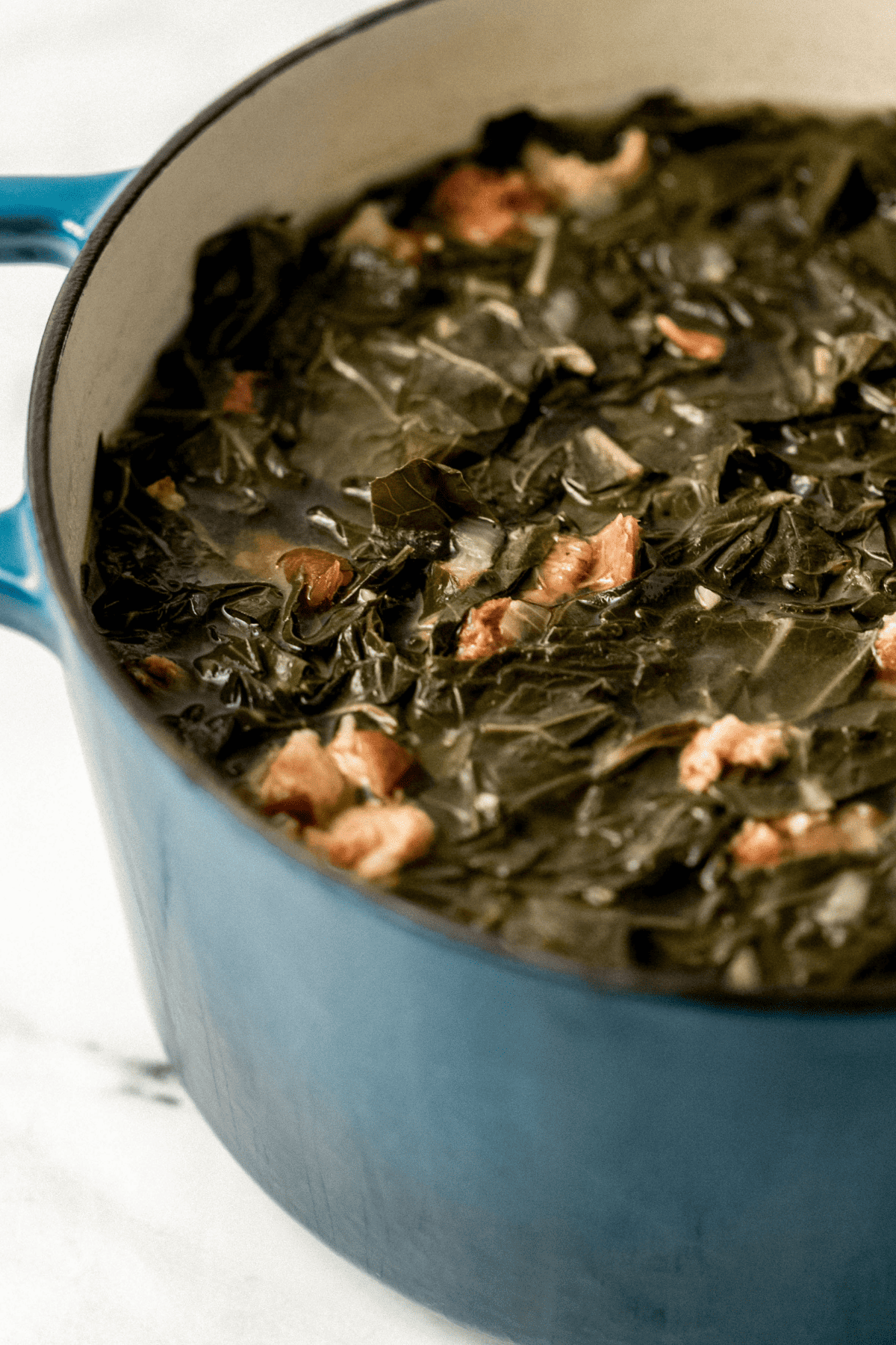 close up side view of cooked greens in large pot 