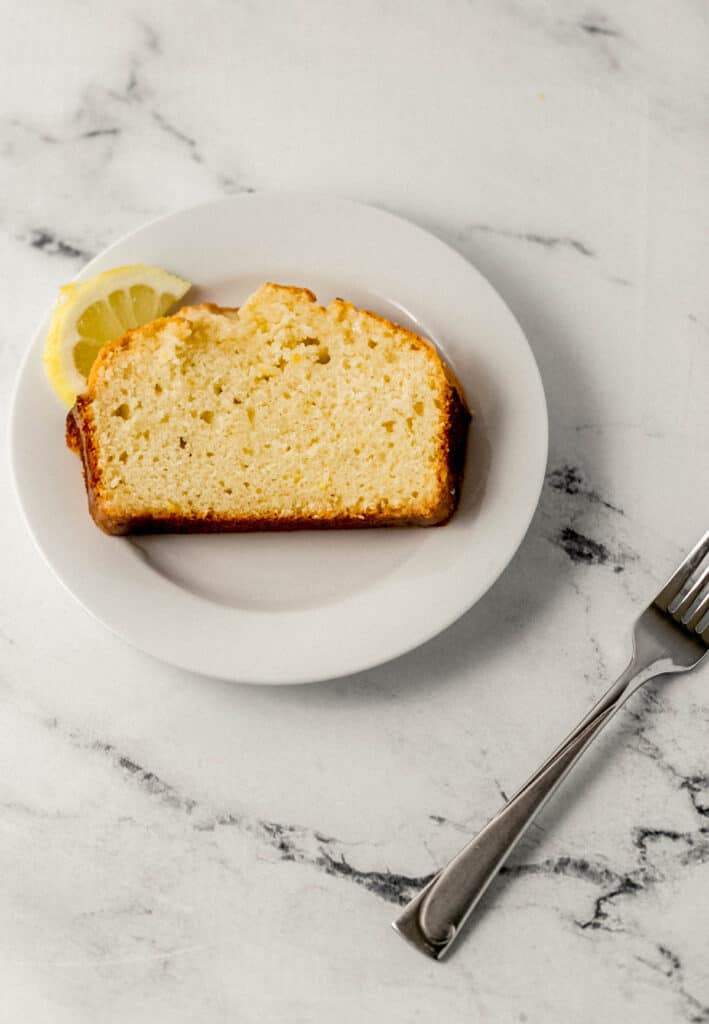 slice of bread on white plate beside fork