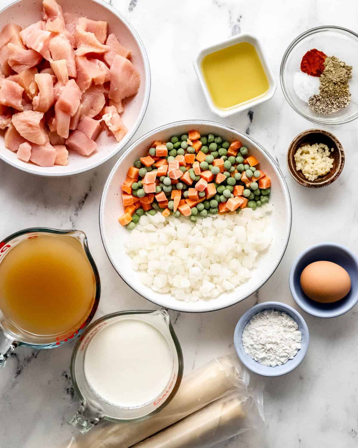 Overhead view of ingredients needed to make pot pie in separate bowls. 