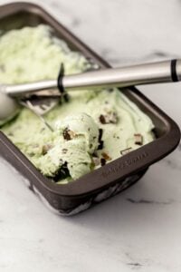 Close up view of frozen ice cream in pan with scoop.