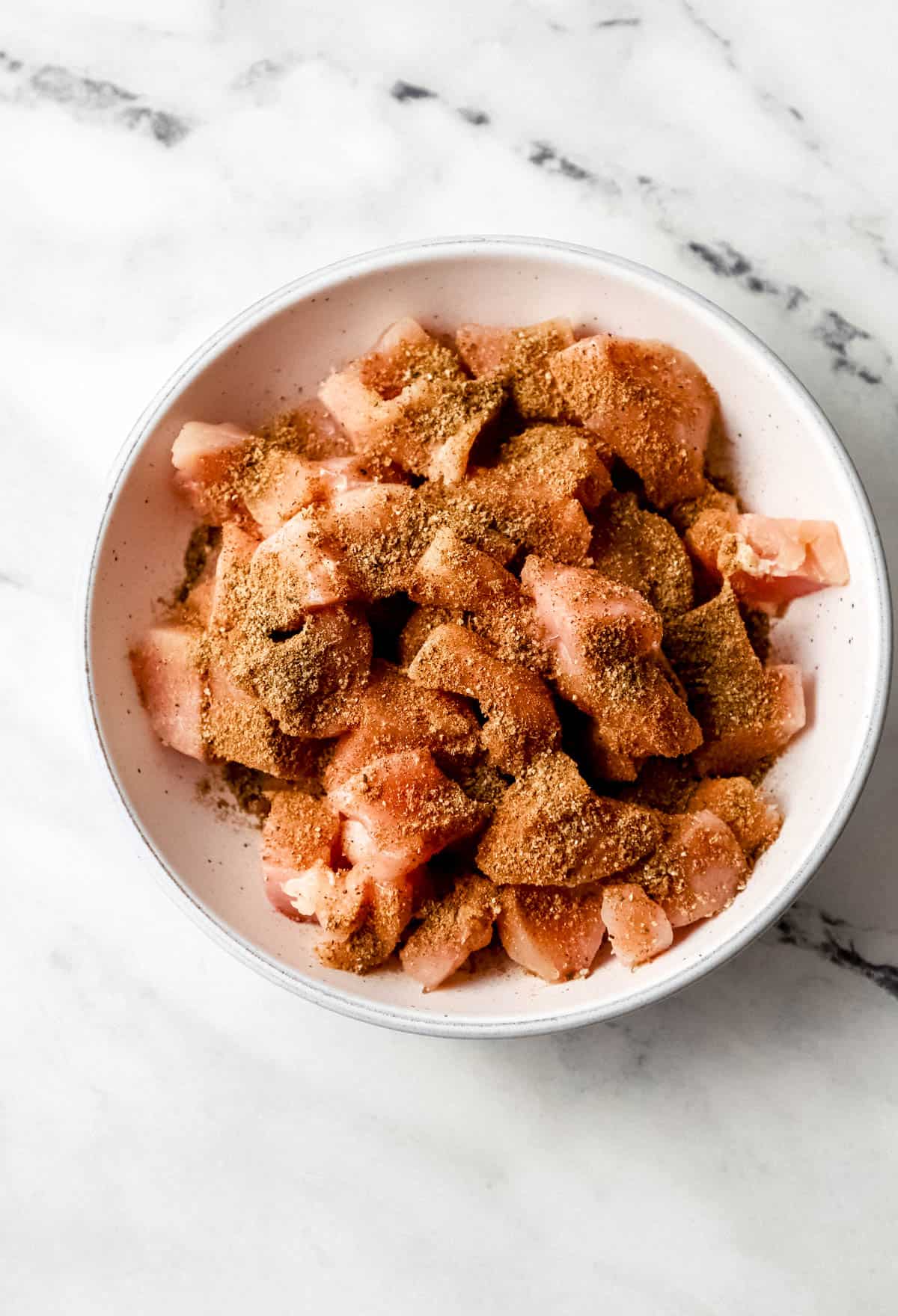 seasoned raw chicken in bowl 