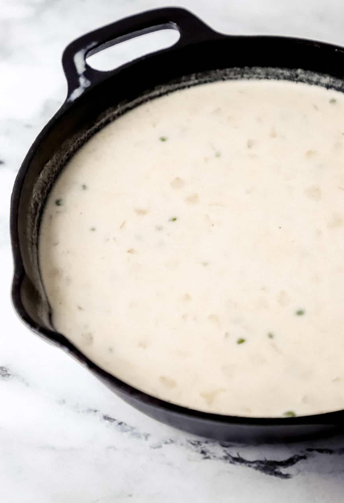 close up side view of sauce for pot pie in cast iron skillet 