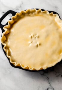 Close up view of pie brushed with egg wash before baking.
