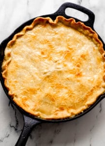 Overhead view of baked pot pie in cast iron skillet.