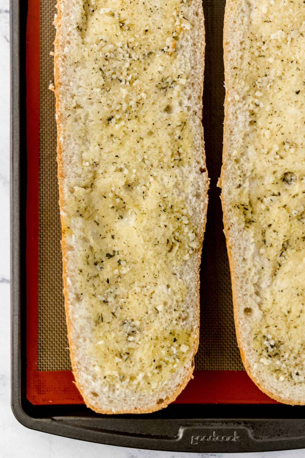butter mixture spread on bread on baking sheet 