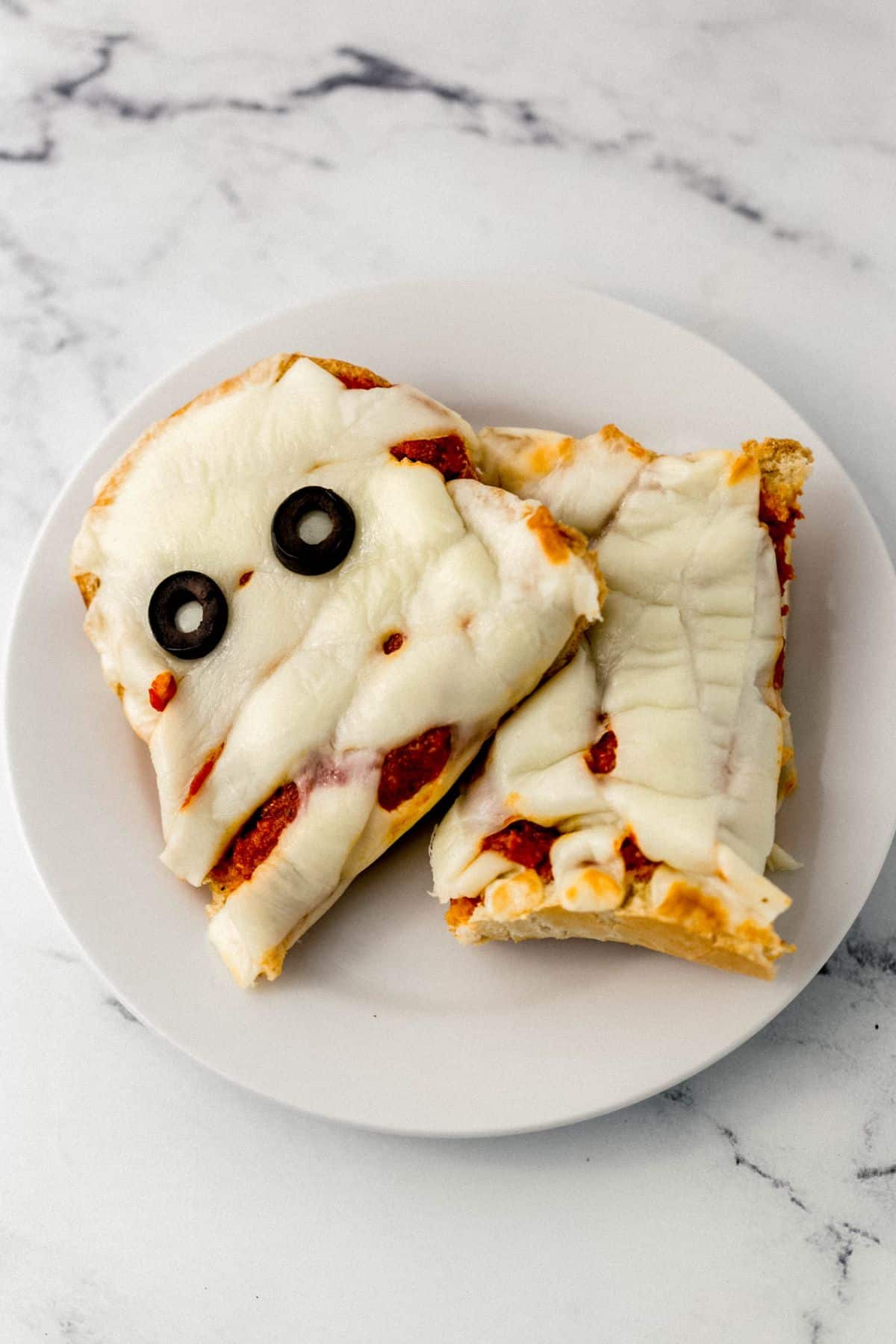overhead view of piece of mummy pizza on white plate