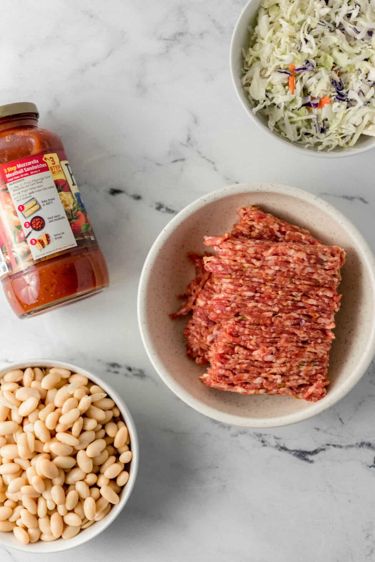 overhead view of ingredients needed to make soup in separate bowls and a jar