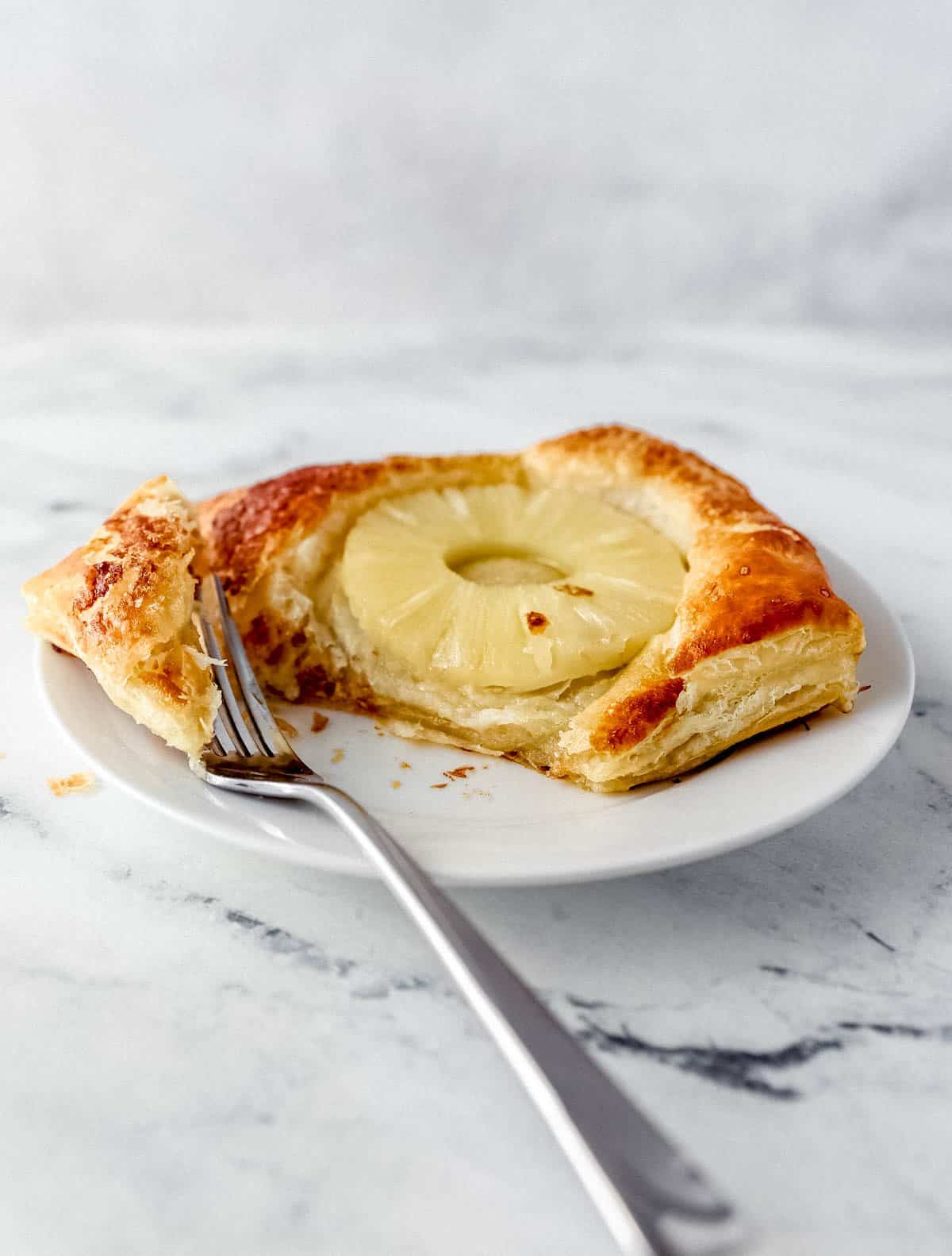 close up side view of tart on white plate with fork in it