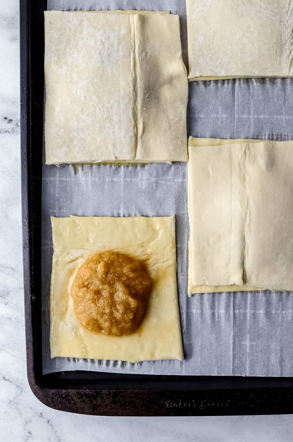 puff pastry dough square added to the top of each tart on parchment lined baking sheet 