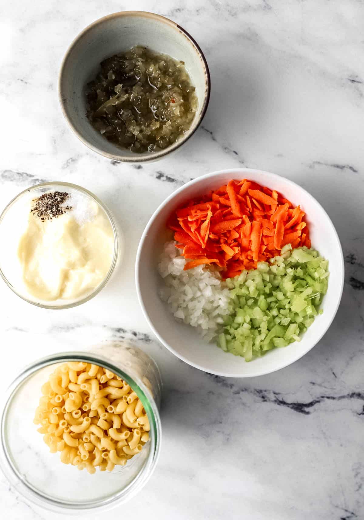 ingredients needed to make pasta salad in separate bowls 