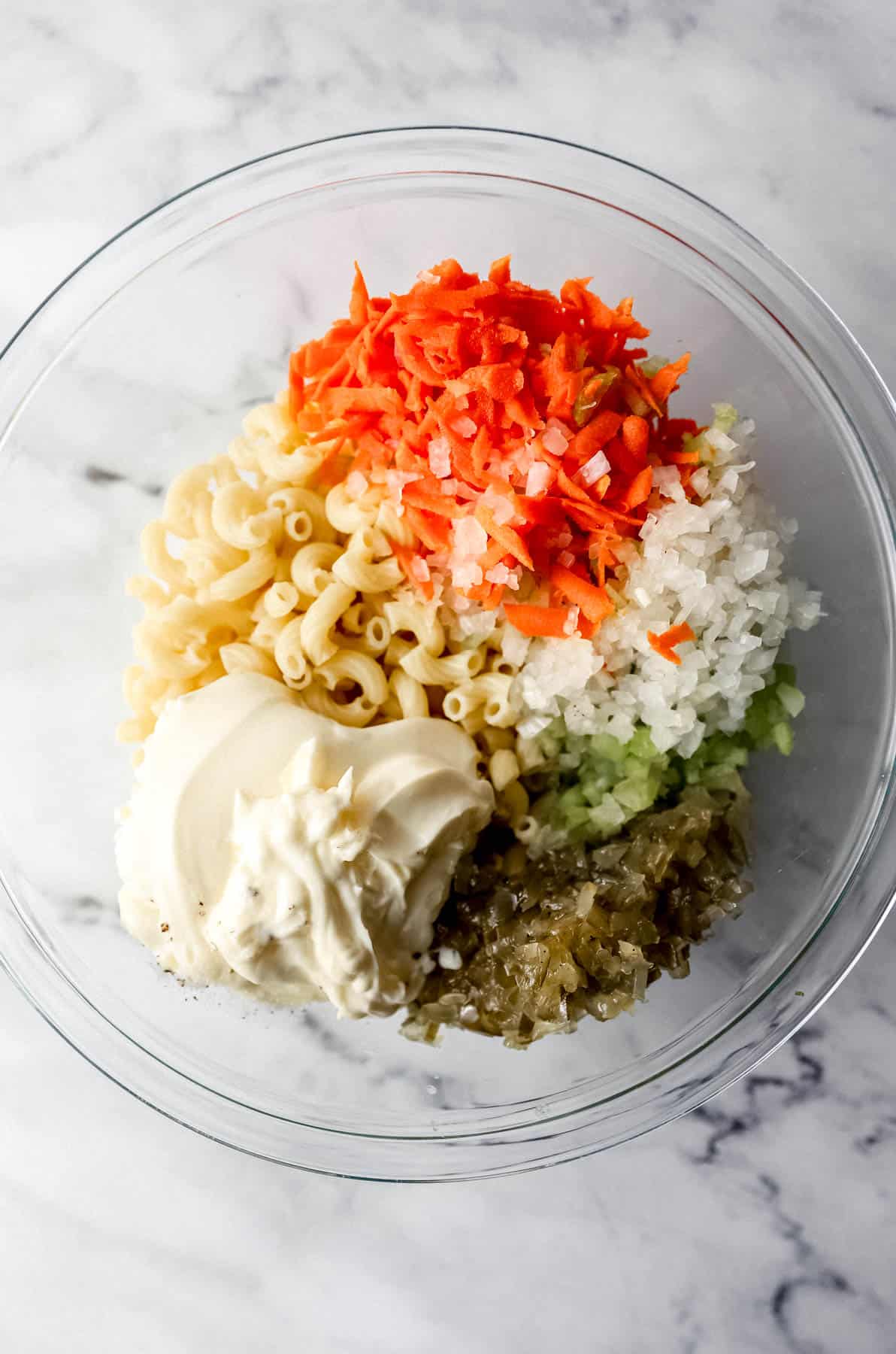 pasta salad ingredients in large glass mixing bowl 