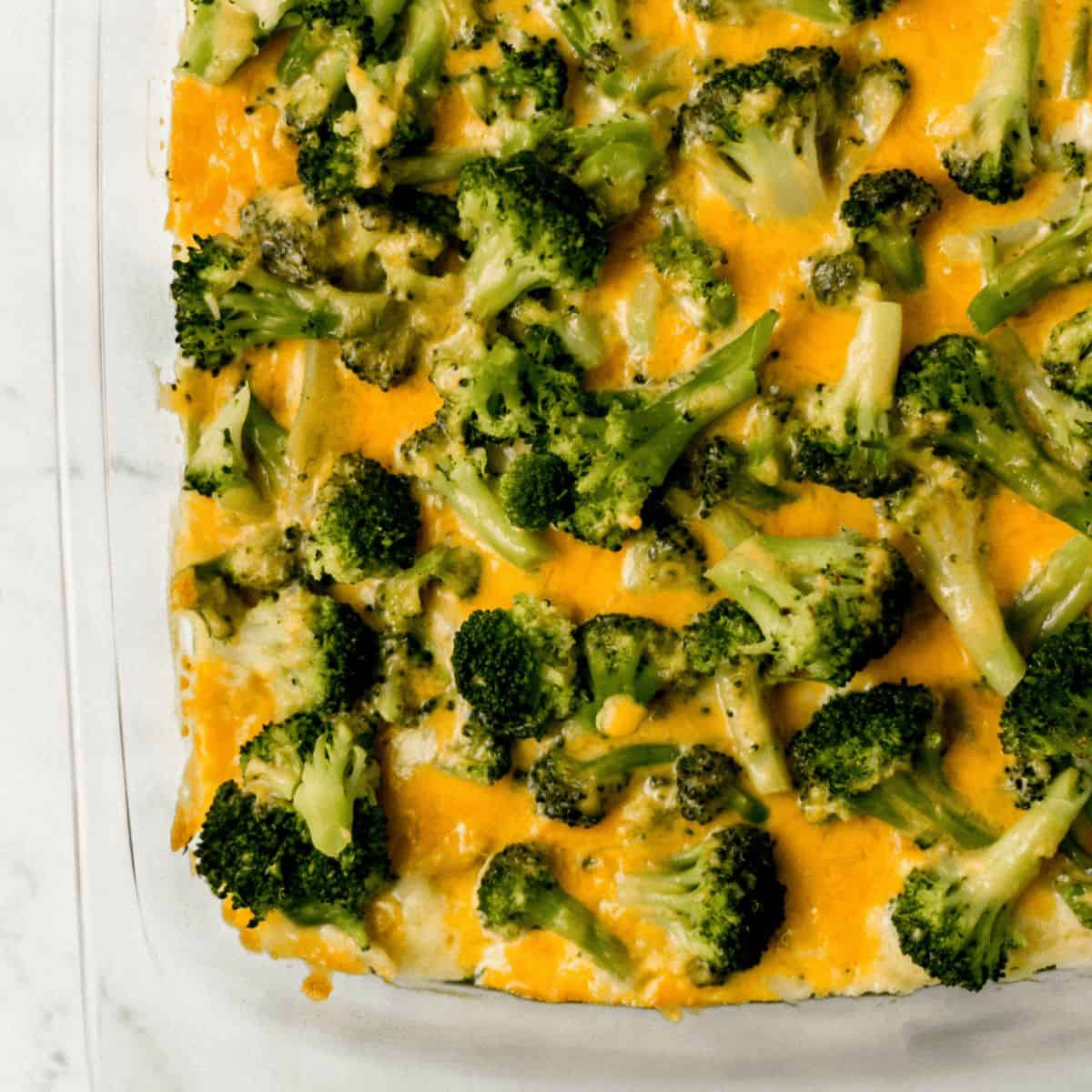 finished broccoli casserole in glass baking dish on marble surface