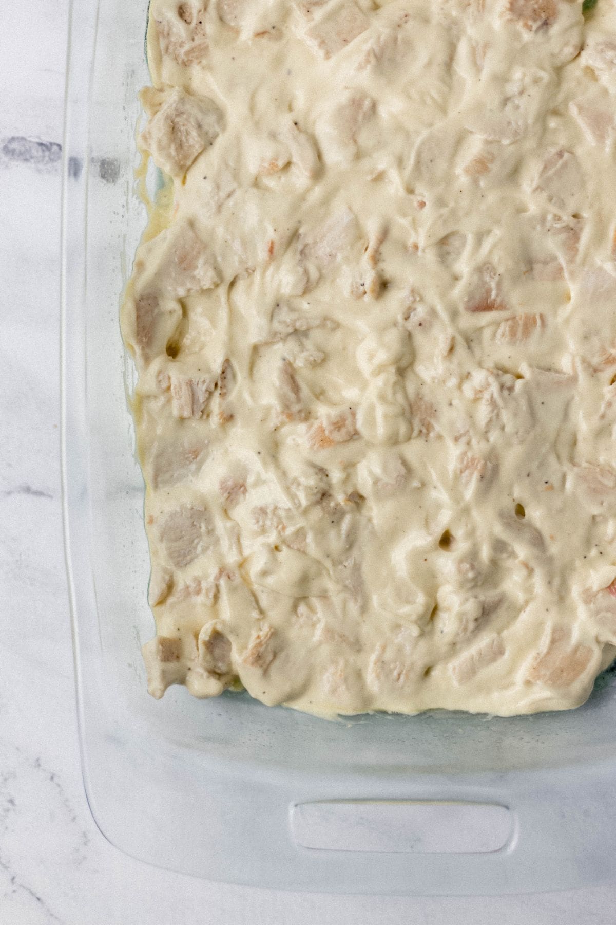 chicken mixture added to glass casserole dish 