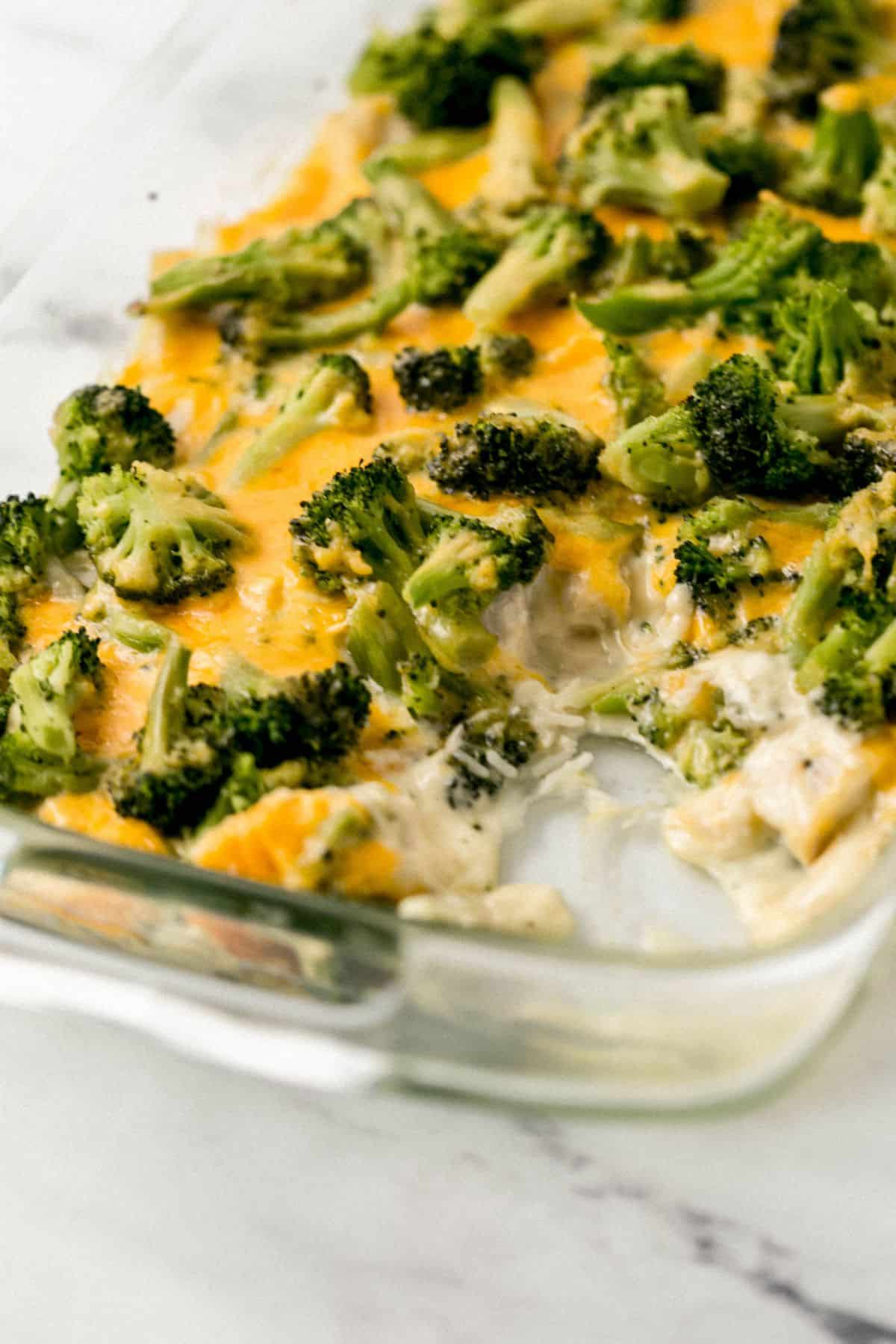 close up view of finished casserole in glass baking dish with a scoop taken out of it 