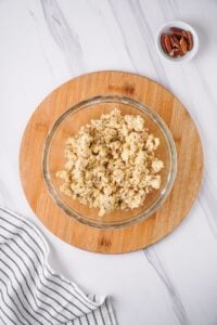 Overhead view of crust ingredients added to a glass mixing bowl.