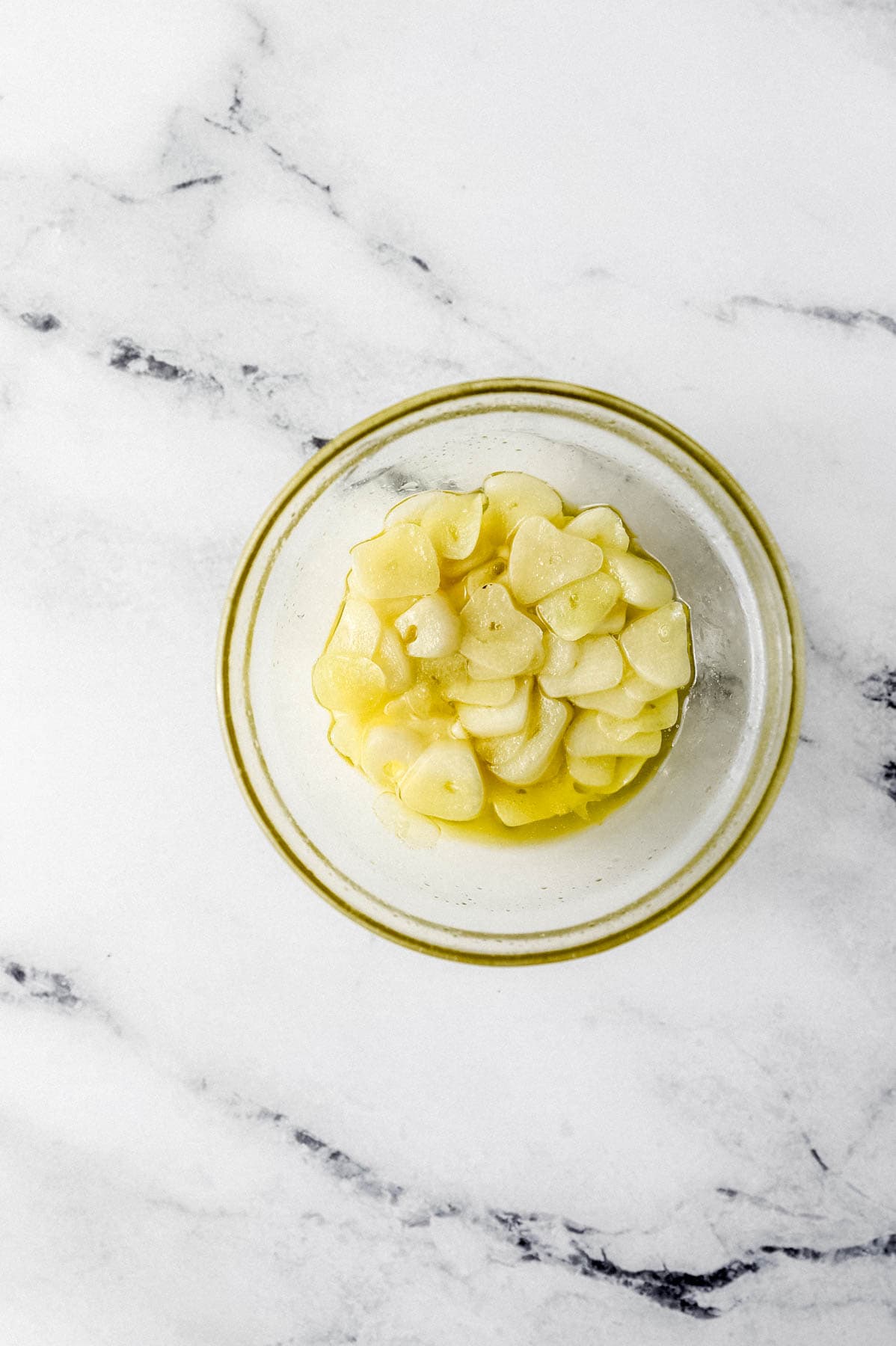 sliced garlic and oil in small glass bowl 