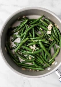 Overhead view of finished green beans in skillet.