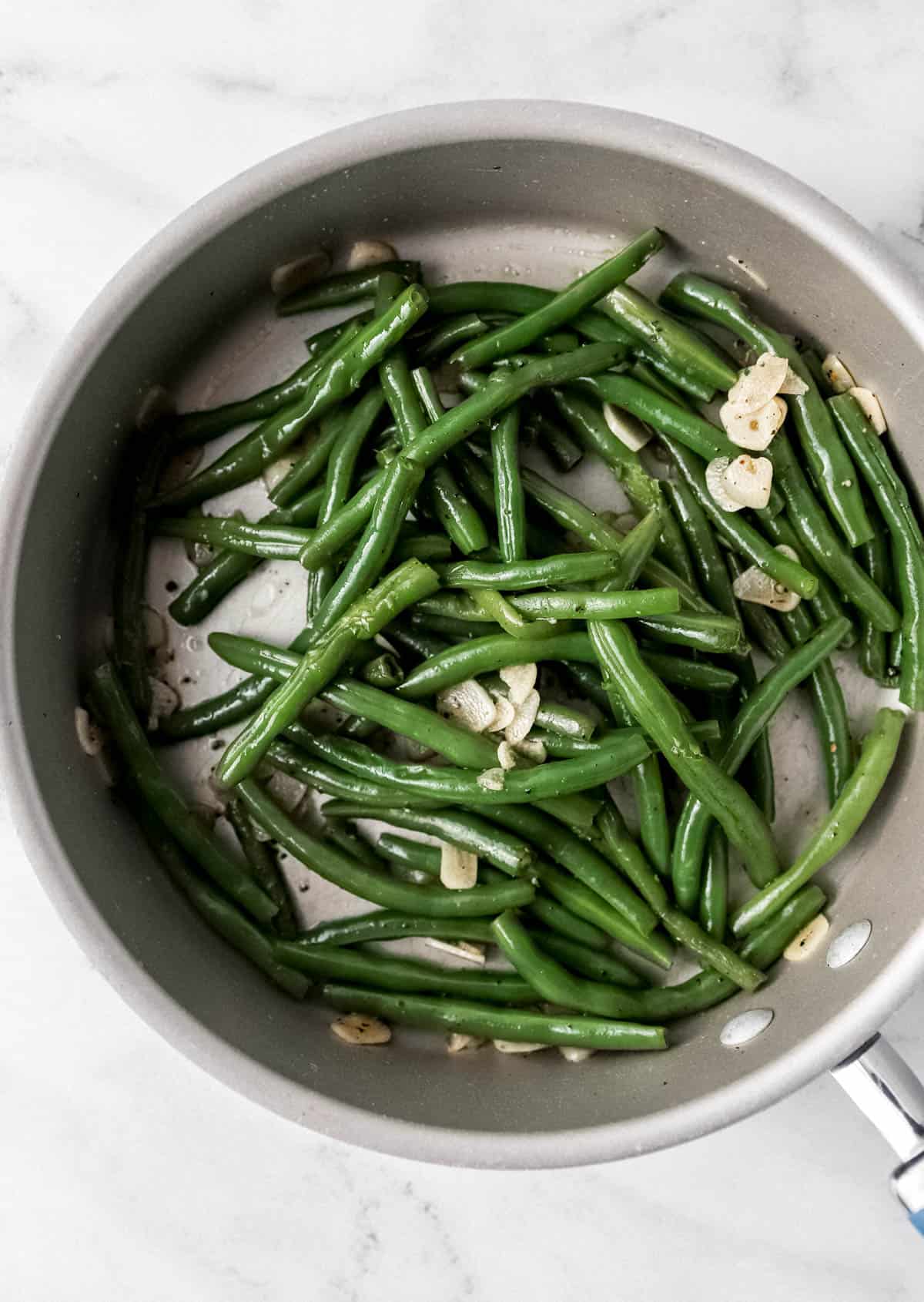 overhead view of cooked green beans in large skillet 
