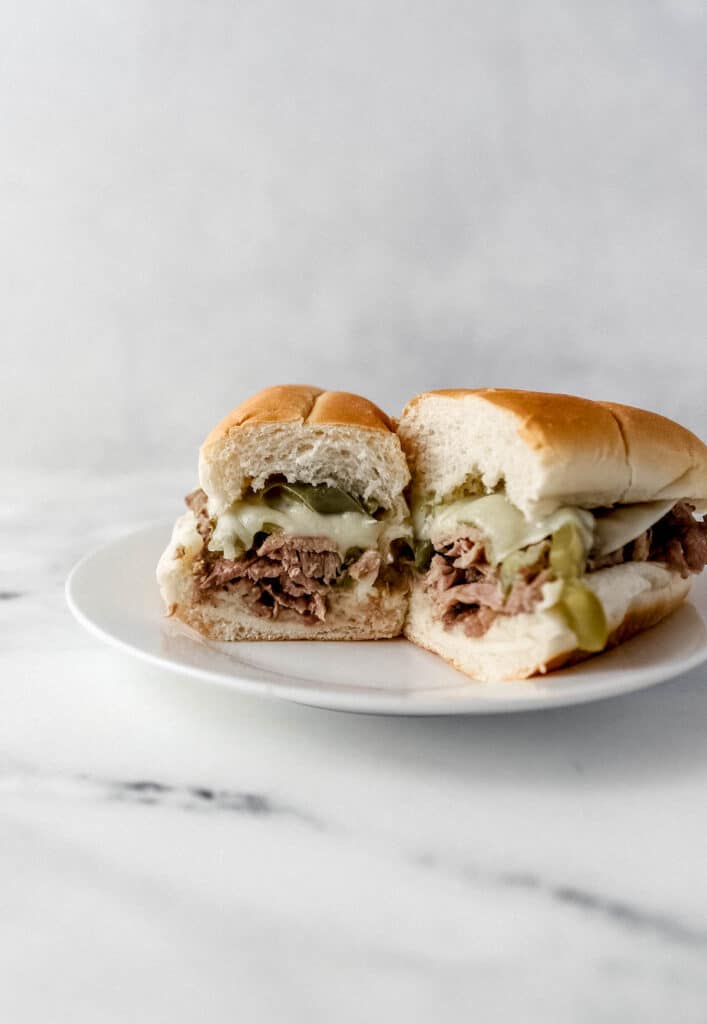 cheesesteak cut in half on white plate