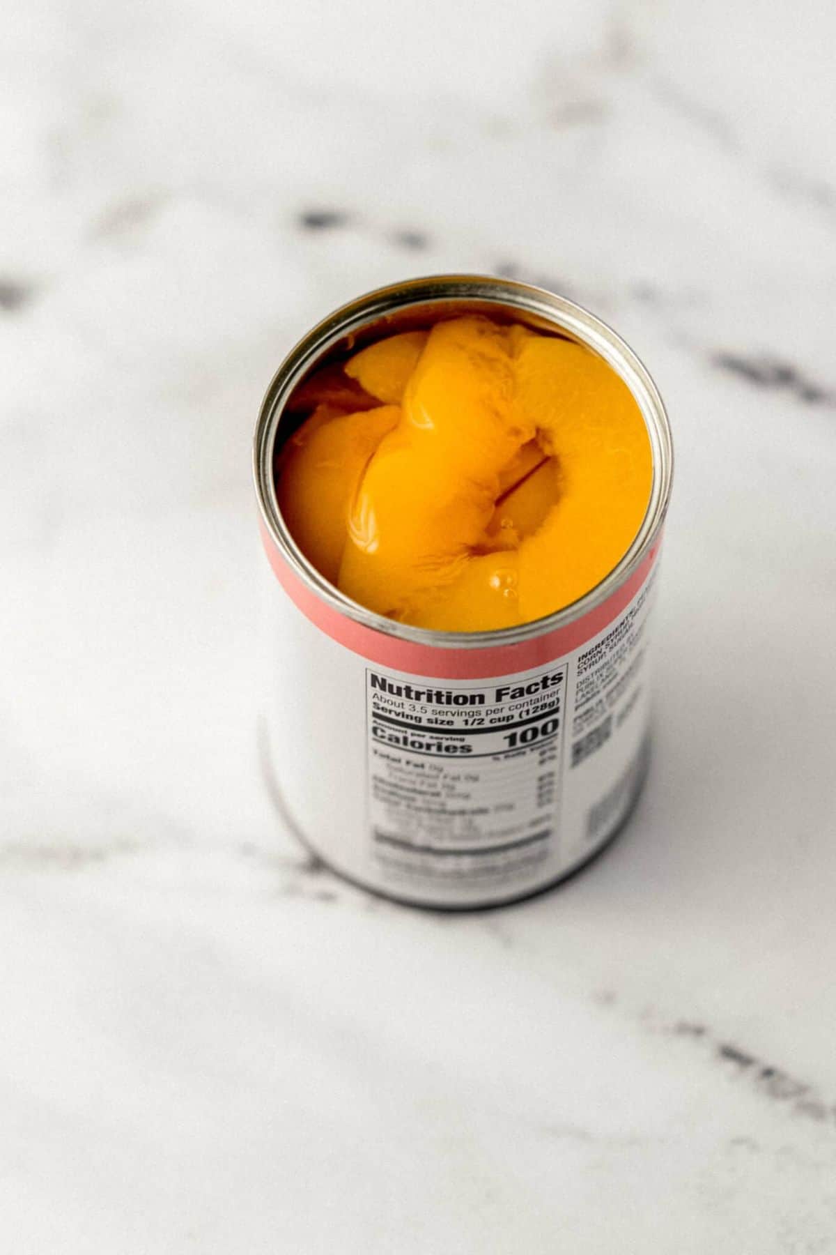 close up overhead view of open can of sliced peaches