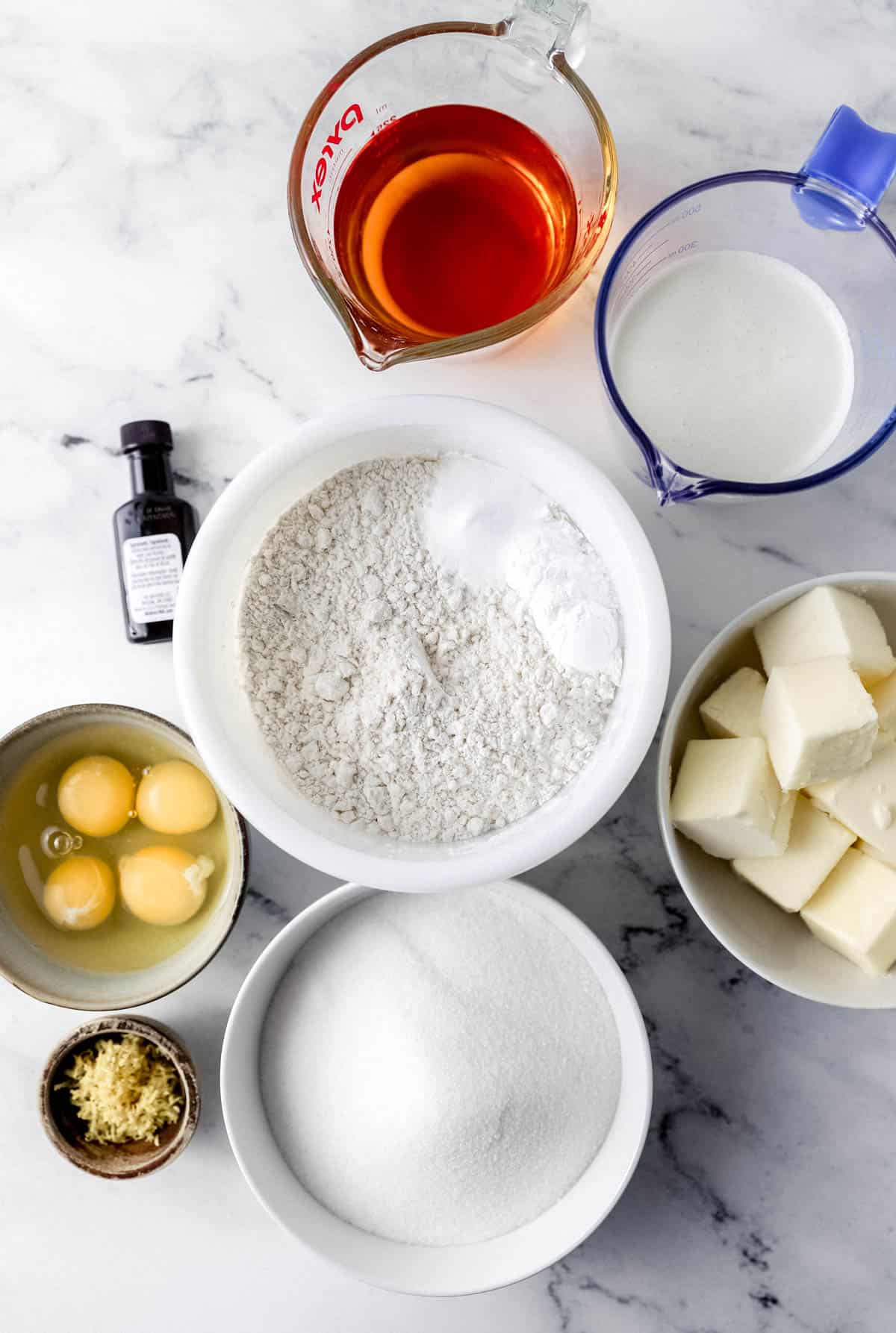 Overhead view of ingredients needed to make rum cake in separate bowls and containers. 