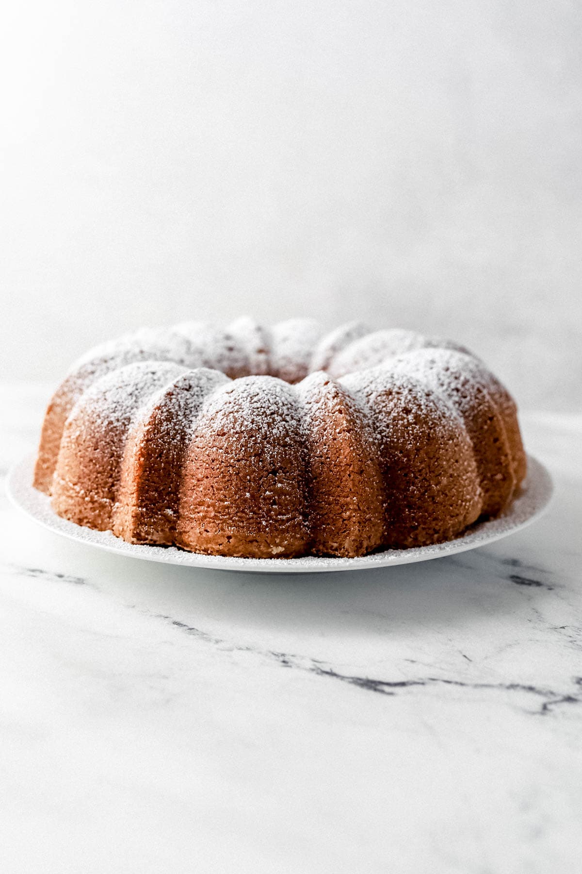 Close up side view of finished cake topped with powdered sugar. 