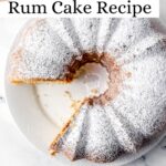Cake topped with powdered sugar with a piece cut out of it pin with text overlay.