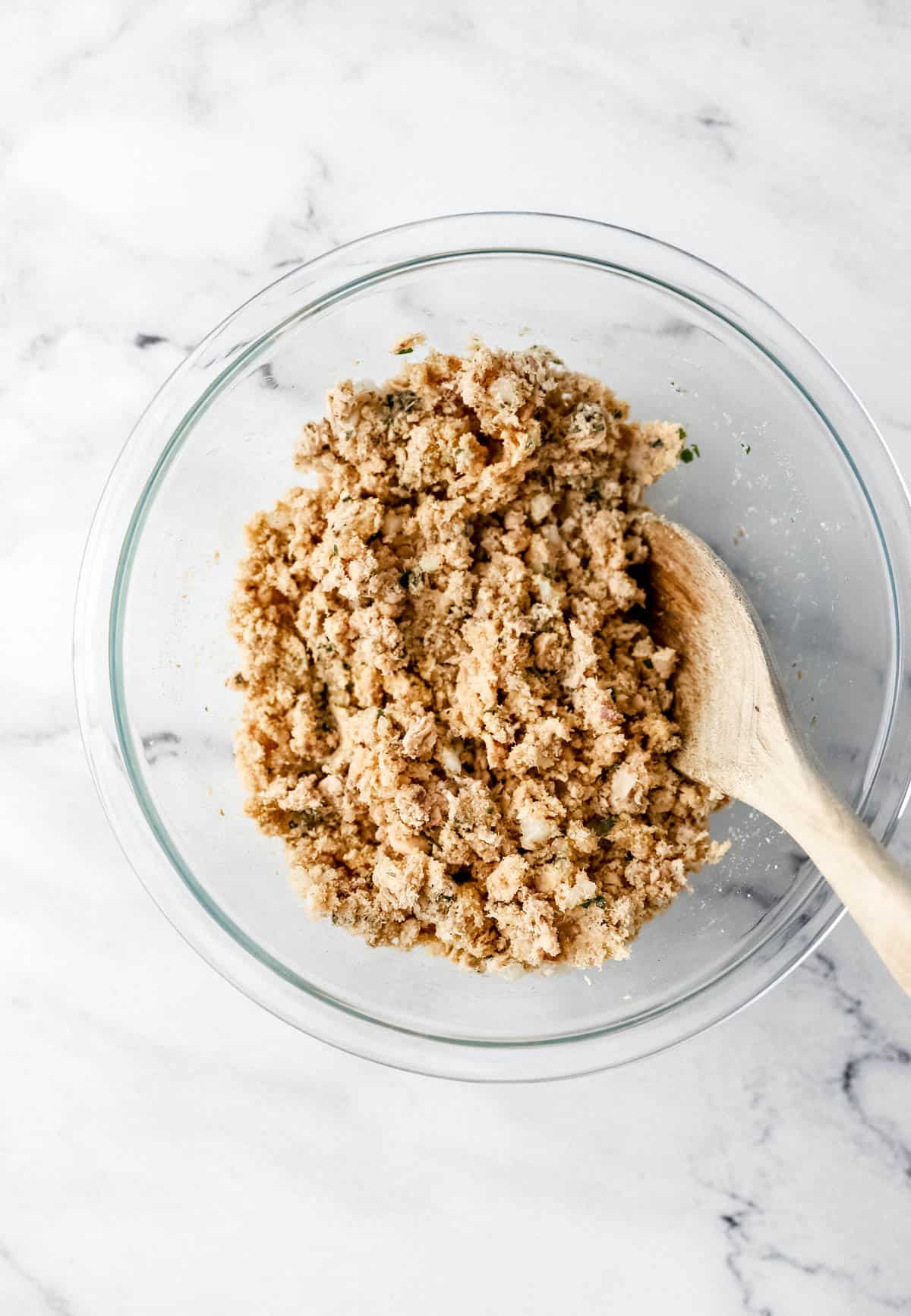 Breadcrumbs and egg added to glass mixing bowl with the other salmon recipe ingredients. 