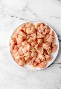 Overhead view of seasoned chicken on a plate.
