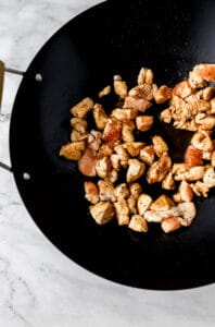 Chicken in wok with soy sauce and sesame oil.