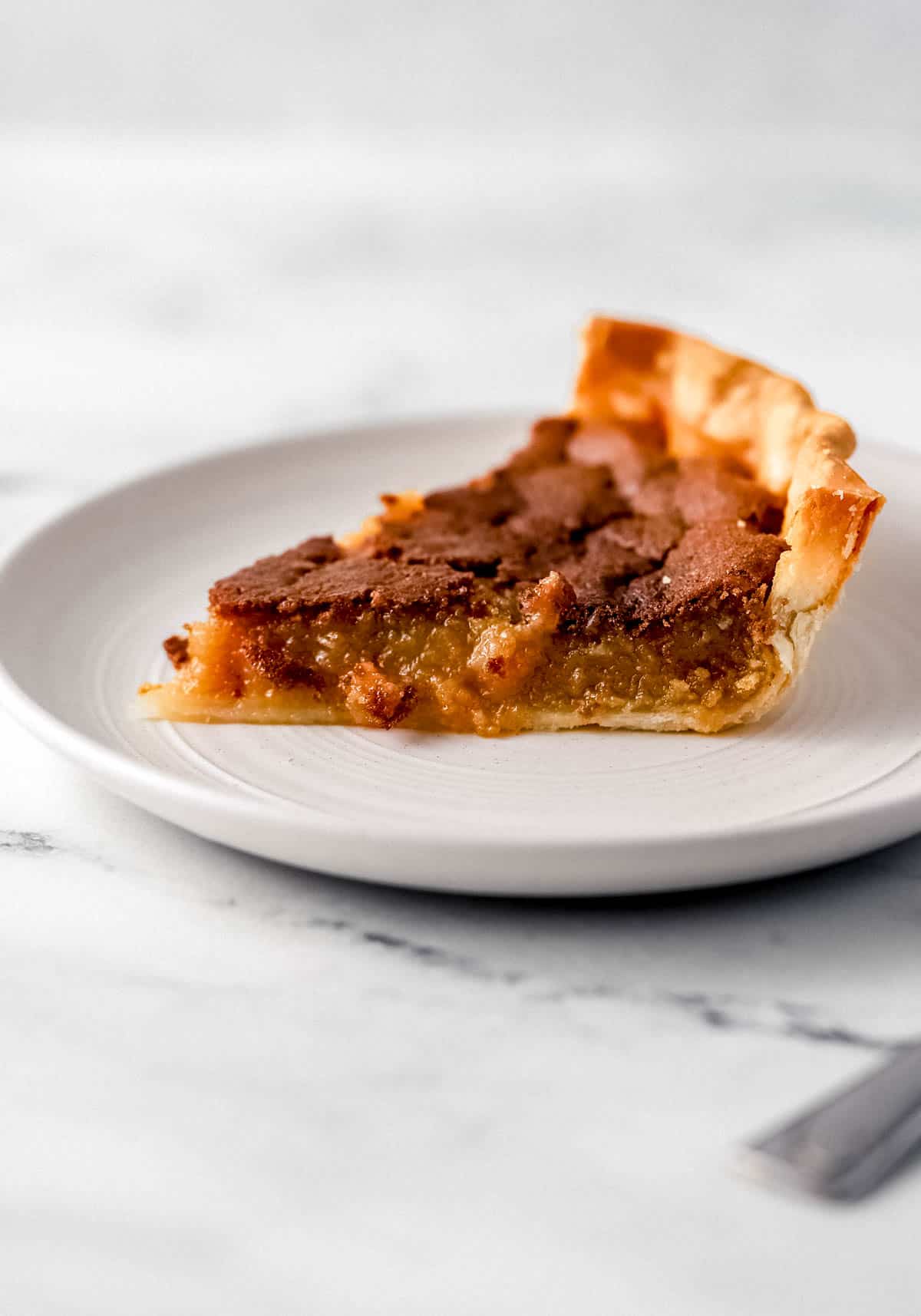 Close up side view of slice of baked pie on white plate. 