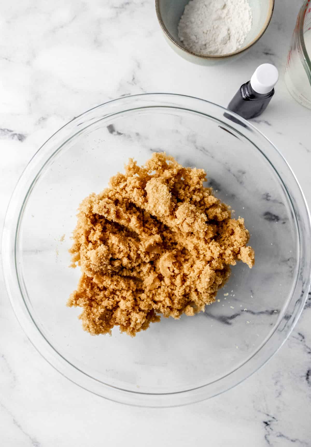 Butter and brown sugar combined in glass mixing bowl. 