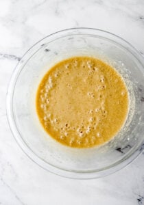 Overhead view of glass mixing bowl with pie ingredients combined.