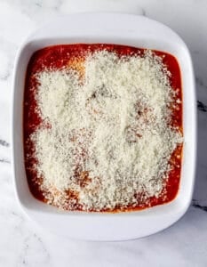 Parmesan cheese added over the sauce and chicken in the dish.