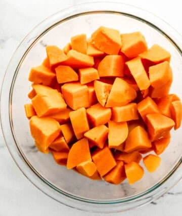 Boiled sweet potatoes in a glass mixing bowl.