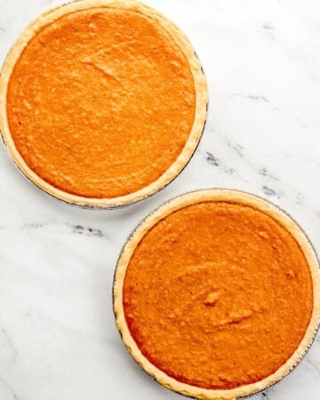 Two baked pies on marble surface.