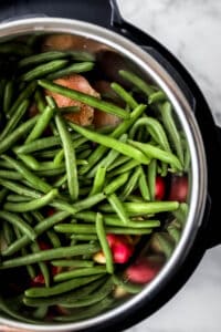 Green beans added to the instant pot with the chicken and potatoes.