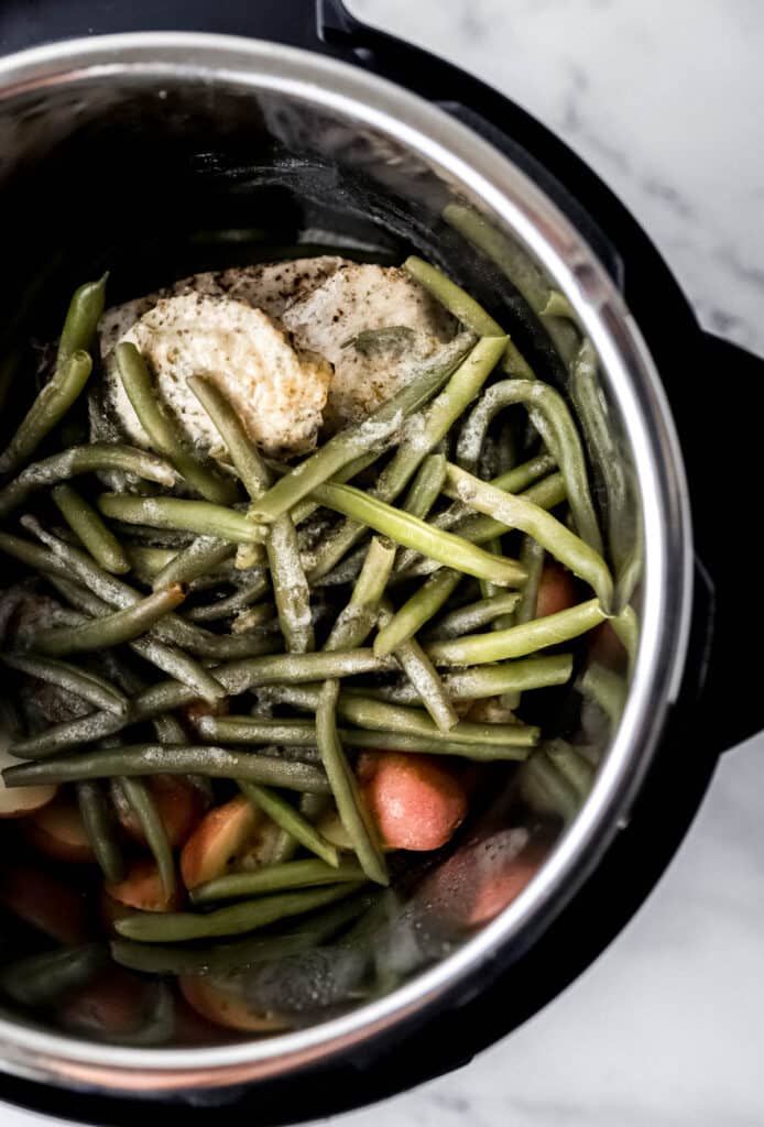 Overhead view of cooked chicken, potatoes, and green beans in the instant pot.