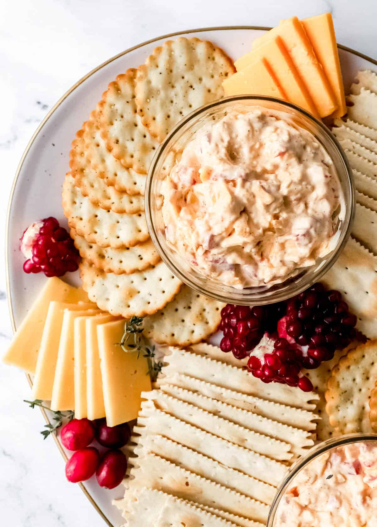 Close up view of snack board with pimento cheese in small glass bowls on it. 