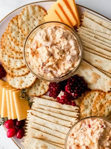 Overhead view of snack board with pimento cheese on it all on a white tray.