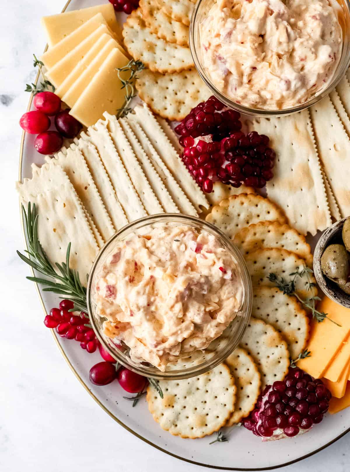 Overhead view of pimento cheese in small glass bowl on snack tray. 