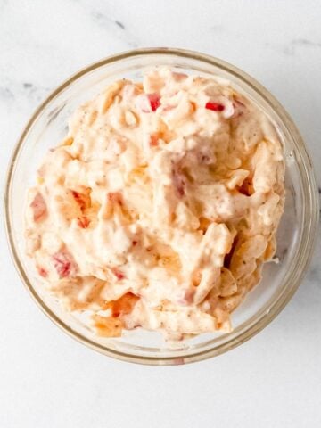 Overhead view of pimento cheese in glass bowl.