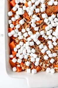 Casserole ingredients layer in white baking dish before baking.