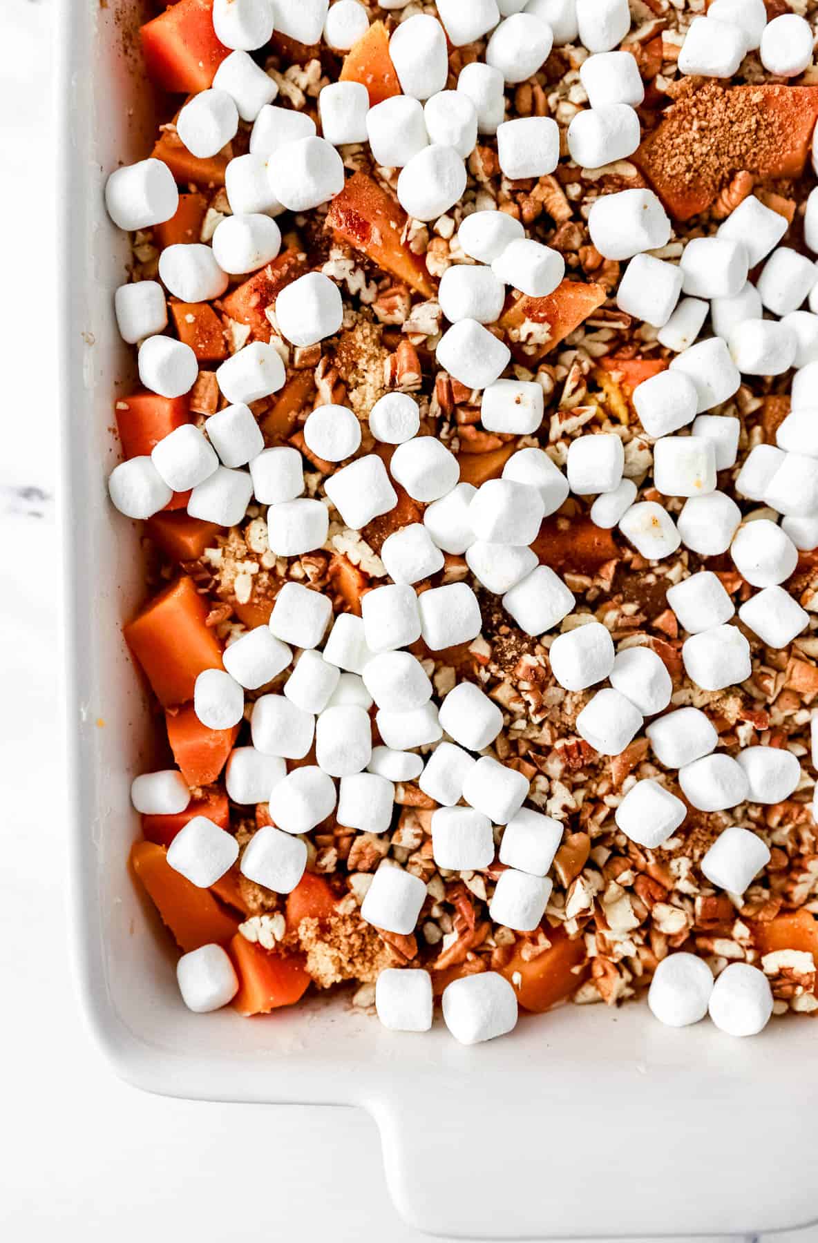 Assembled casserole in white baking dish before baking. 