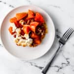White plate with single serving of casserole on it beside a fork.